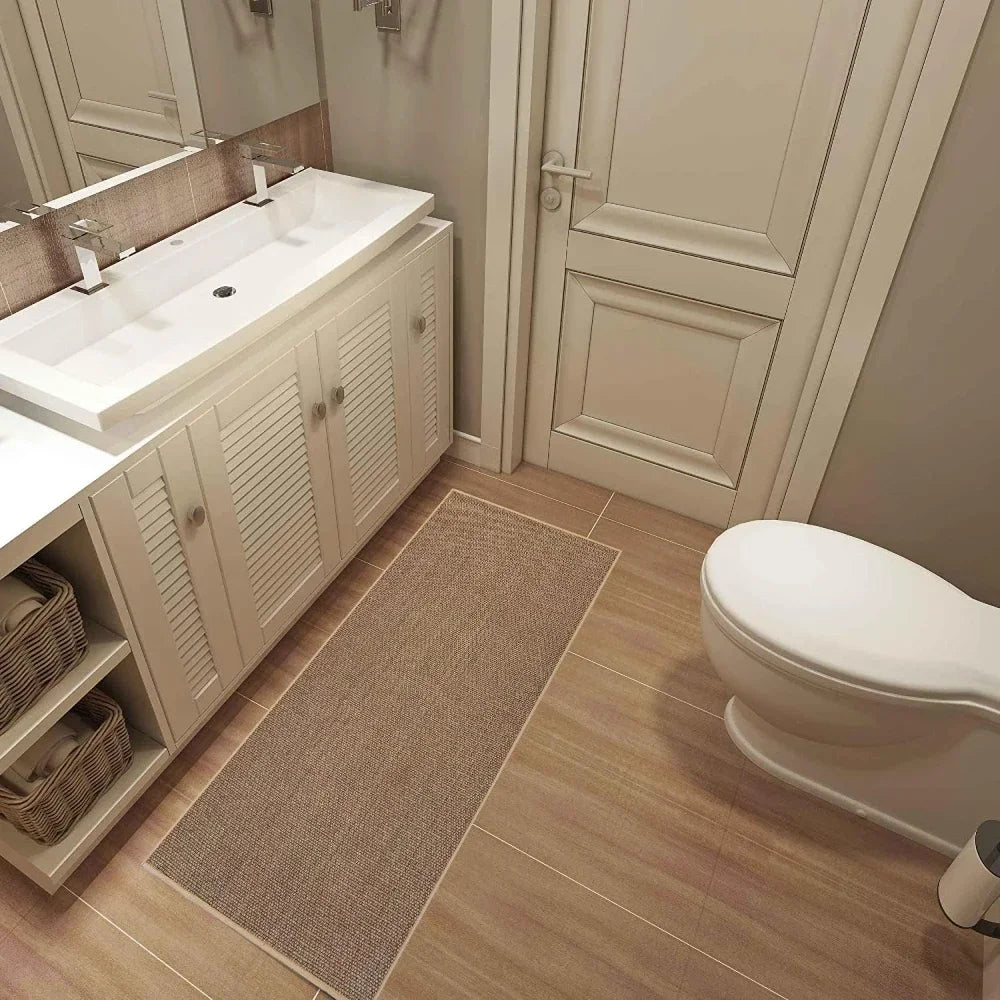 A rectangular beige runner rug with a natural rubber backing placed on a light wood floor.
