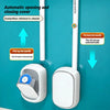 A wall-mounted disposable toilet brush set with a handle and cleaning solution is shown in white against a teal background.