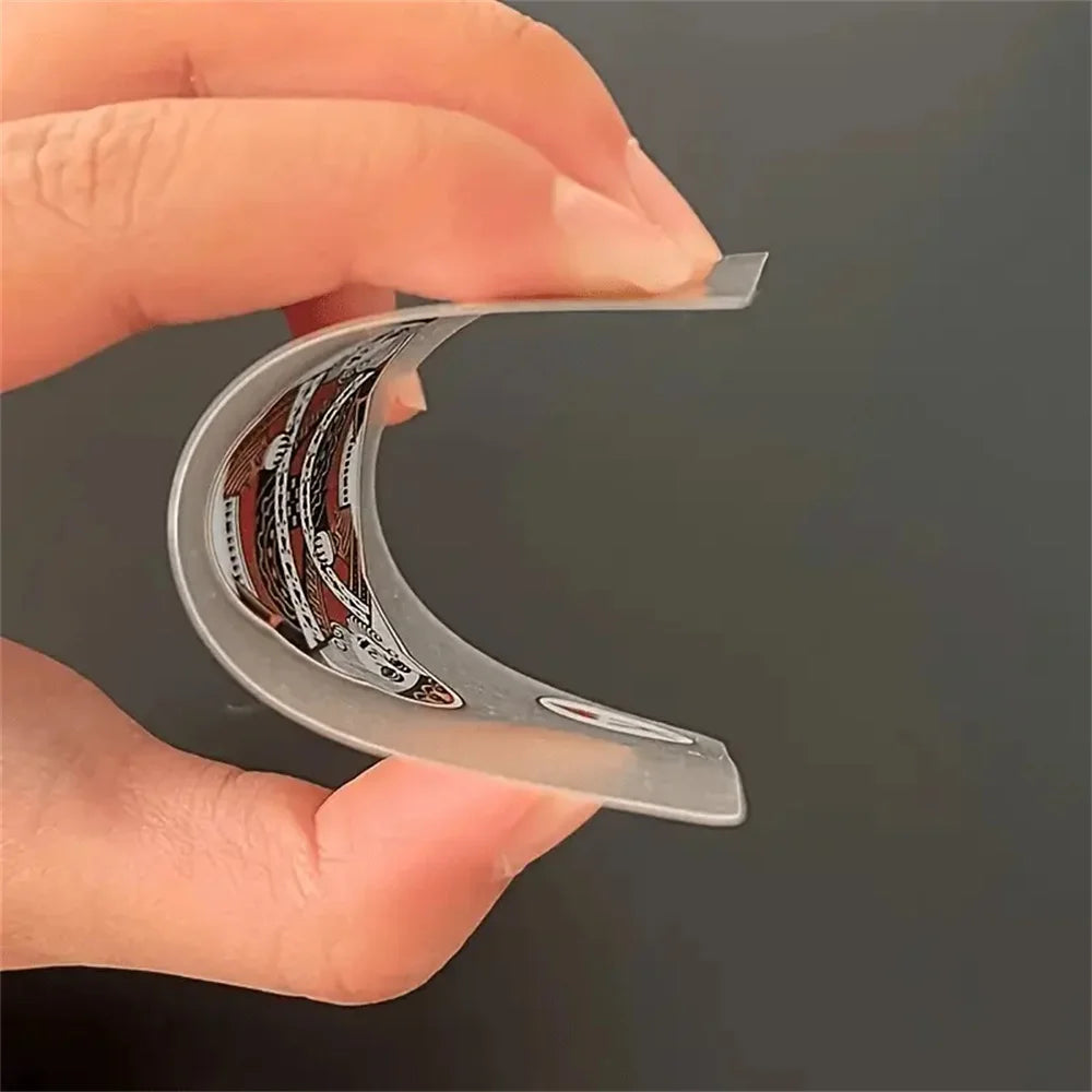 Une main tient une carte jouet en PVC transparente, montrant le design détaillé des cartes.