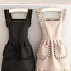A black Korean style cotton kitchen apron with adjustable neck strap and ruffled details.