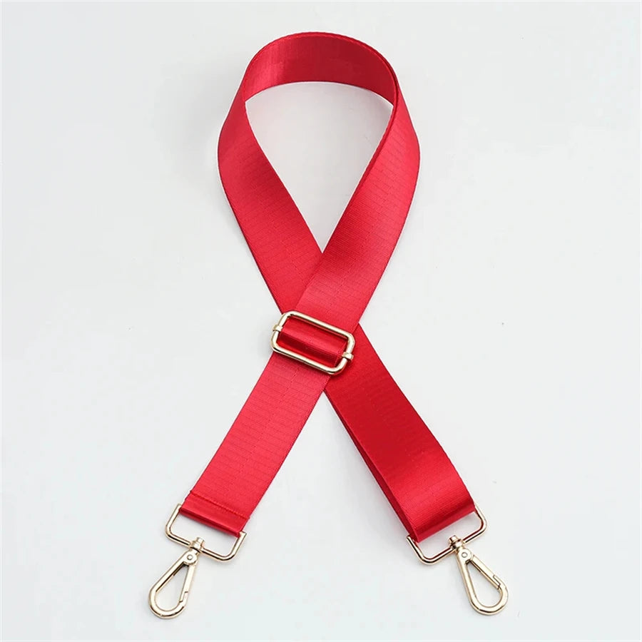 A bright red nylon bag strap with a gold buckle shown diagonally.