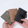 A hand holds a premium PU leather bi-fold wallet in shades of olive green, tan, and black.