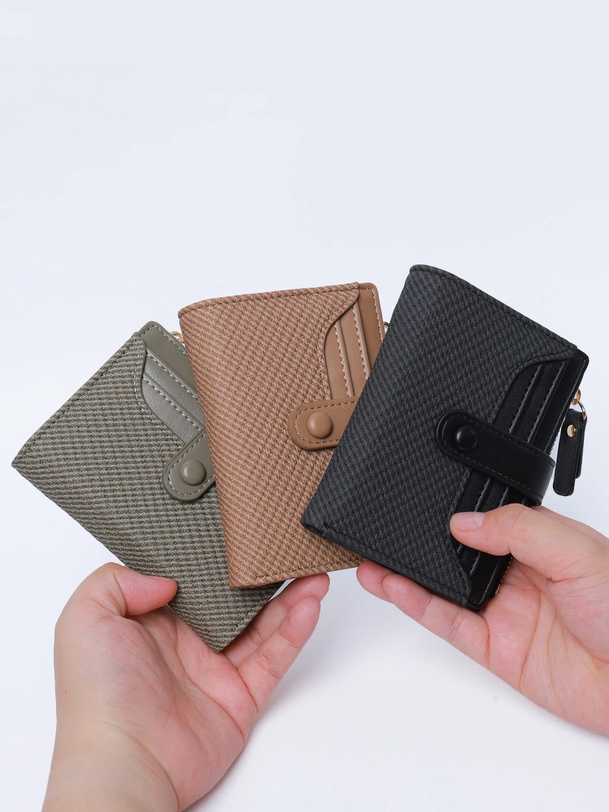 A hand holds a premium PU leather bi-fold wallet in shades of olive green, tan, and black.