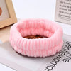 Pink microfiber wrist sweatband and scrunchies for face washing shown on a white surface.