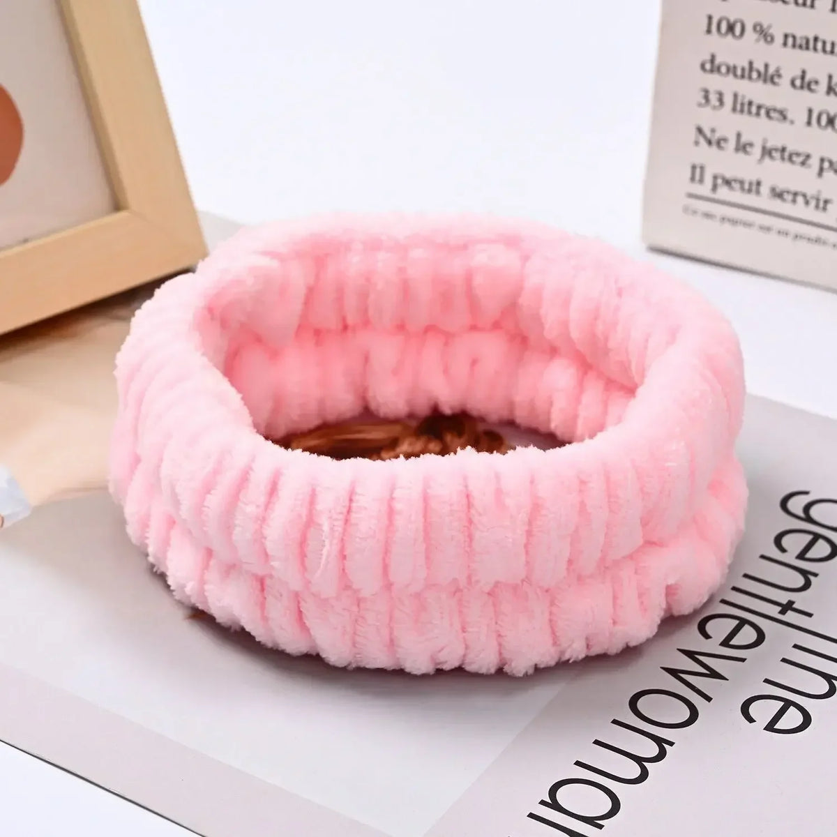 Pink microfiber wrist sweatband and scrunchies for face washing shown on a white surface.