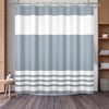 A shower curtain featuring a vertical geometric stripe pattern in shades of white and light blue gray.