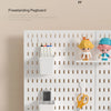 A white freestanding pegboard organizer with multiple shelves and hooks displaying various tools and small items.