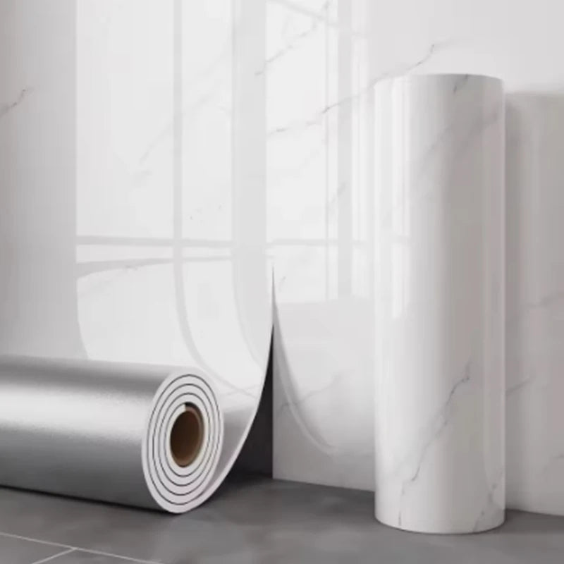 A roll of white marble self-adhesive wallpaper is shown standing vertically against a white wall.