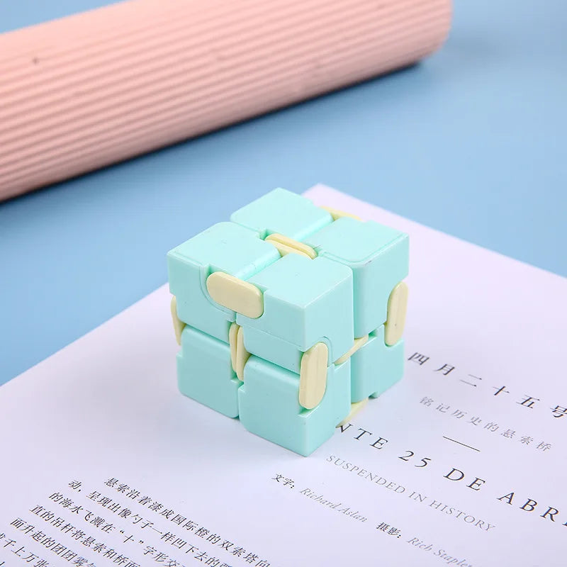 A light blue infinity magic cube fidget toy resting on a white sheet of paper.
