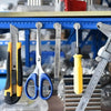 A collection of metal and plastic tools, including scissors, pliers, and a caliper, displayed on a blue shelf.