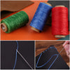 Rolls of waxed polyester thread in green, blue, and red next to hand sewing needles demonstrating thread usage.