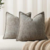 A close-up of a textured gray chenille throw pillow cover resting on a light-colored sofa or blanket.