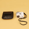 White 60X LED handheld magnifier with UV light and black storage pouch on a beige background.