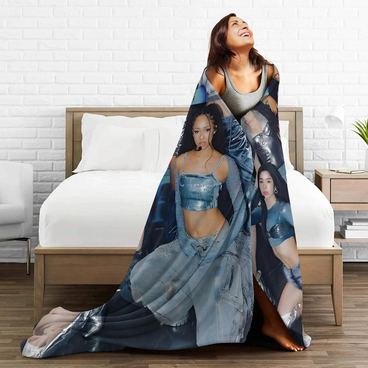 A woman wearing a blue patterned microfiber fleece throw blanket is lying on a bed.