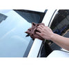 A hand wipes a window with a dark brown rubber sealing strip for automotive noise and weather protection.