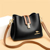 A black women's three-layer leather shoulder bag with a tan strap resting on a light background.