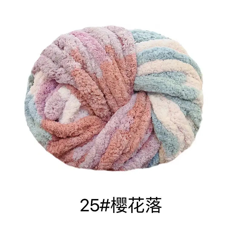 A ball of chunky acrylic yarn in shades of pink, purple, and blue, used for knitting or crochet.