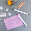 A set of six vinyl weeding and craft tools, including tweezers and a precision tool, laid on a gray surface with a pink note.