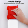 A hand is using a red paint edger tool to prevent hitting a wall while painting.