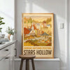 A framed canvas print depicting a scenic autumn landscape with trees and buildings for wall decor.