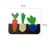 A wooden busy board featuring three vegetable shapes: a carrot, a leek, and a pea pod.