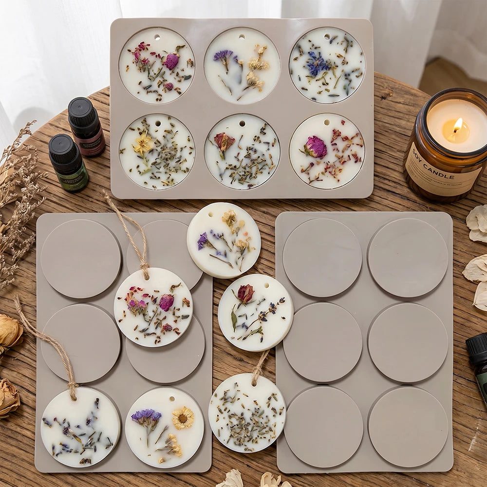 A tray of six silicone molds containing various floral and herbal designs for making soap and aromatherapy discs.