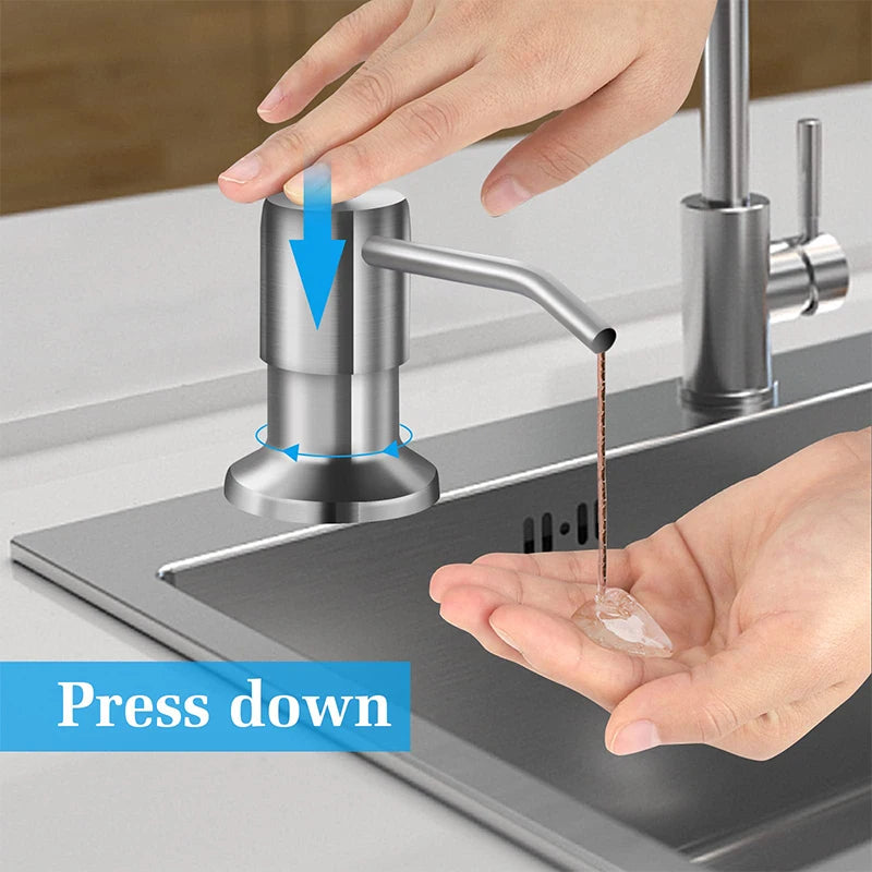 Hand pressing down on a stainless steel under-sink soap dispenser with an extension tube