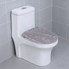 A white toilet with a soft gray flannel seat cover installed in a bathroom.