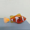 An orange and white light-up sensor swimming fish toy with a translucent yellow fin.