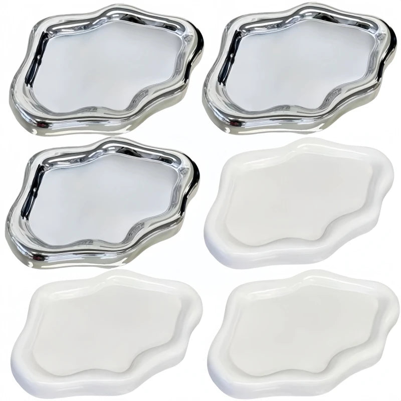 A set of five cloud-shaped silver and white jewelry trays.