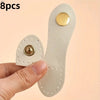 Eight beige leather buckle clasps with gold accents shown being held by a hand