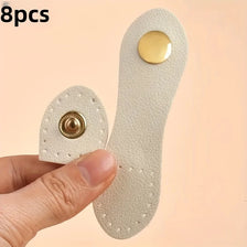 Eight beige leather buckle clasps with gold accents shown being held by a hand