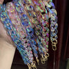 A close-up of colorful resin chains in various shades of blue, purple, and pink, displayed on a hand.