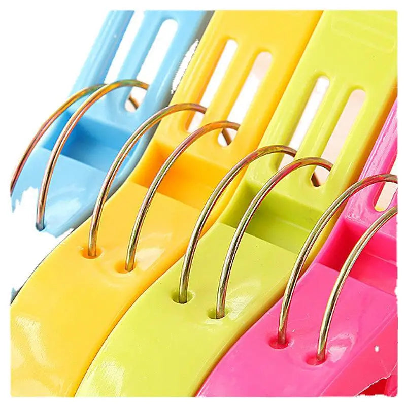 A close-up view of various colored heavy-duty laundry clips for sheets and towels.