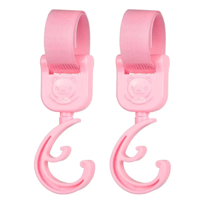 A pair of pink 360° rotating stroller hooks designed for hanging bags and essentials.