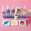 A hand is pouring yellow liquid from a bottle into a small white craft tray, demonstrating the DIY 3D Water Elf Craft Kit for