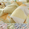 A set of beige and cream cotton duvet covers and pillow shams featuring geometric patterns and a teddy bear decoration.