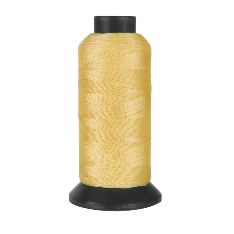 A spool of heavy-duty nylon sewing thread in a golden yellow color.