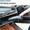 A hand is folding a black fabric sun shade umbrella inside a car's interior, demonstrating its easy storage.