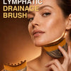 A woman is using a wooden facial lymphatic drainage brush on her face.