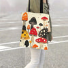 A tote bag featuring a colorful print of various mushrooms carried by a person walking outdoors.