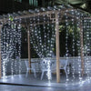 A wooden pergola decorated with strings of twinkling white fairy lights for outdoor or party ambiance.