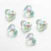 A collection of twenty clear, iridescent acrylic heart-shaped beads for jewelry making.