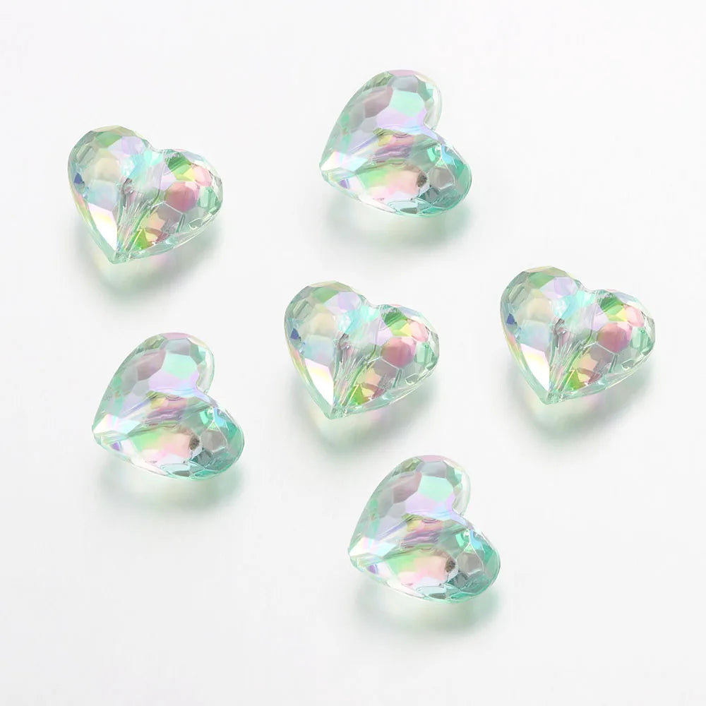 A collection of twenty clear, iridescent acrylic heart-shaped beads for jewelry making.