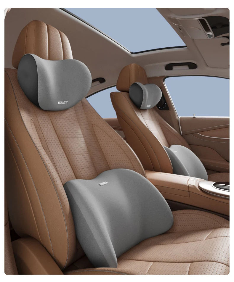 A close-up view of a tan car seat headrest with a gray memory foam pillow providing lumbar support.