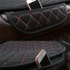 Black quilted car seat covers with red stitching protecting a smartphone.