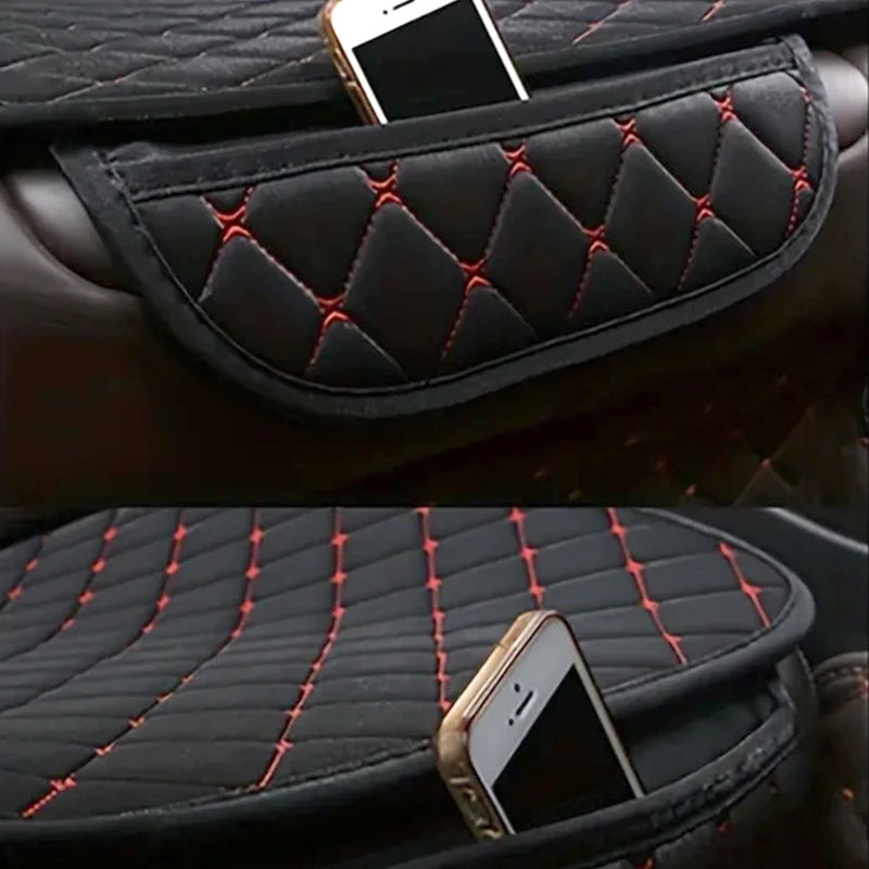 Black quilted car seat covers with red stitching protecting a smartphone.