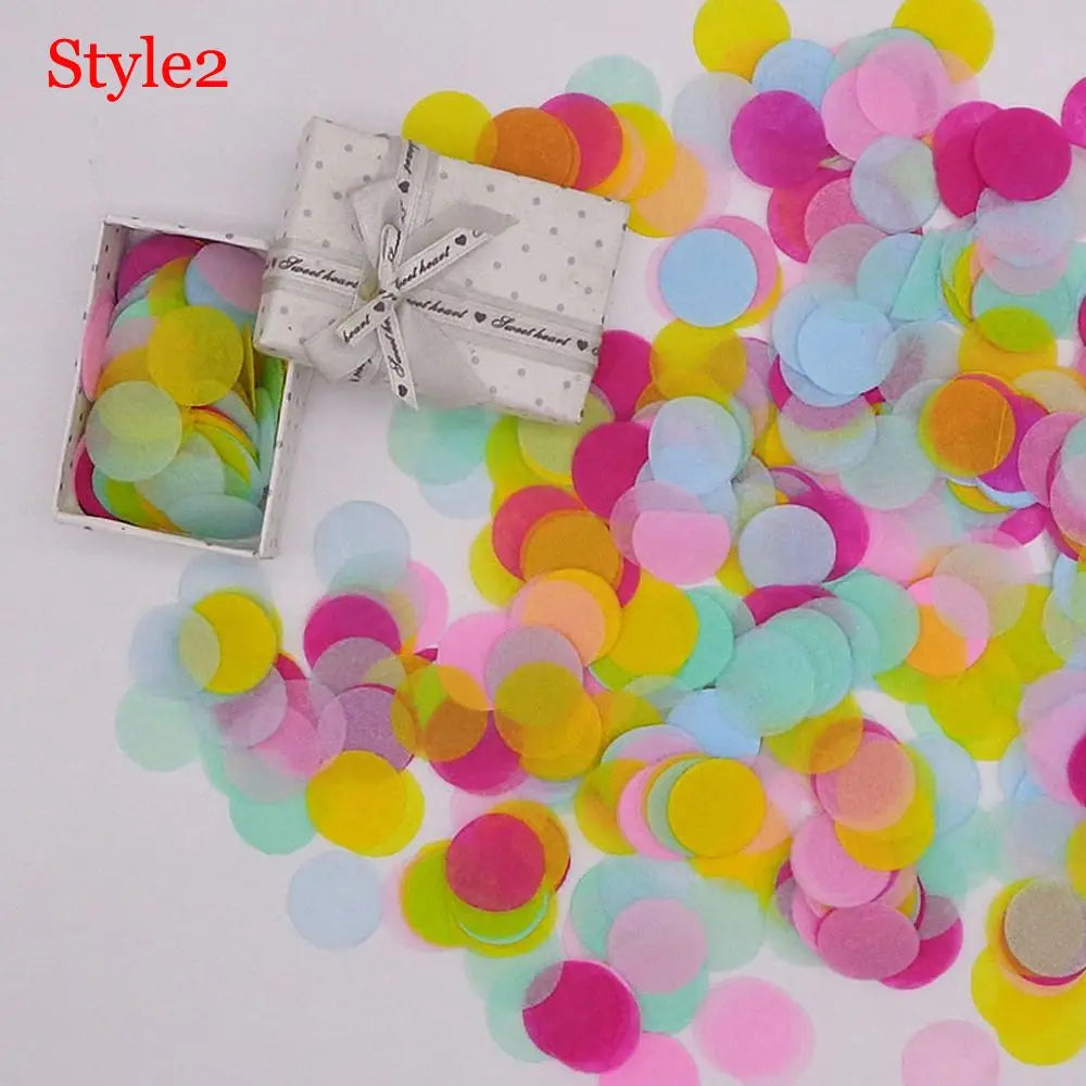 Haufen bunter Papierschnipsel (rosa, gelb, blau) neben einer verpackten Geschenkbox