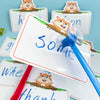 A close-up of dry erase fly swat game cards featuring cute cartoon squirrels and text like some and thank