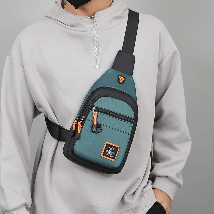 A gray hoodie features a dark teal water-resistant crossbody bag attached to the shoulder strap.